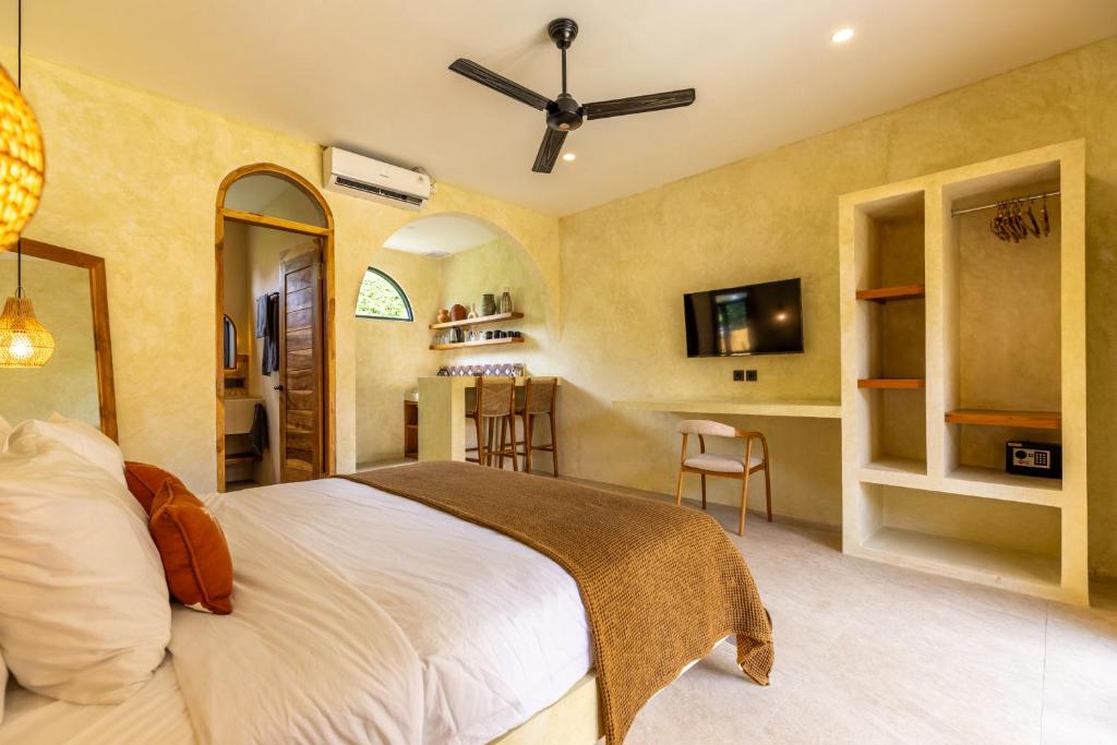 een slaapkamer met een groot bed en een keuken bij Terracota Villas in Kuta Lombok