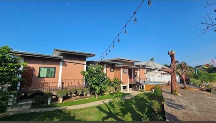 a group of houses in a yard with a kite at River Bend Villas in Mae Rim
