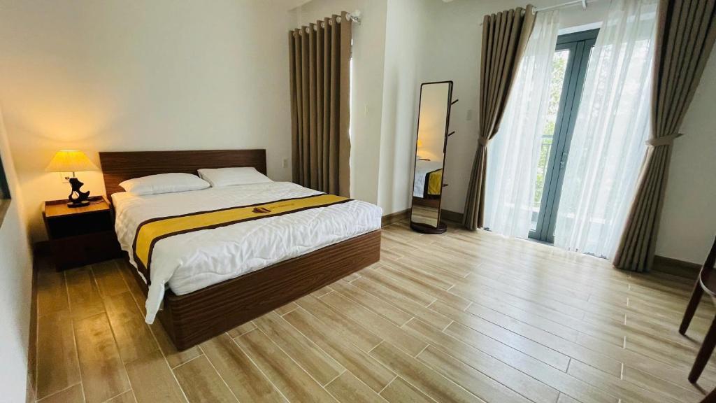 a bedroom with a bed and a large window at LTC Hotel in Long Thành