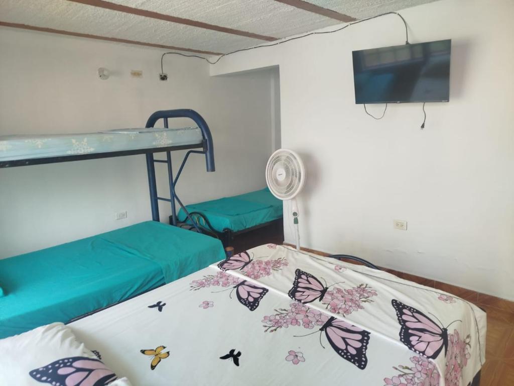 una stanza con un letto a castello con farfalle sulle lenzuola di Villa Itzae Hotel - Piscina y Naturaleza a Viotá