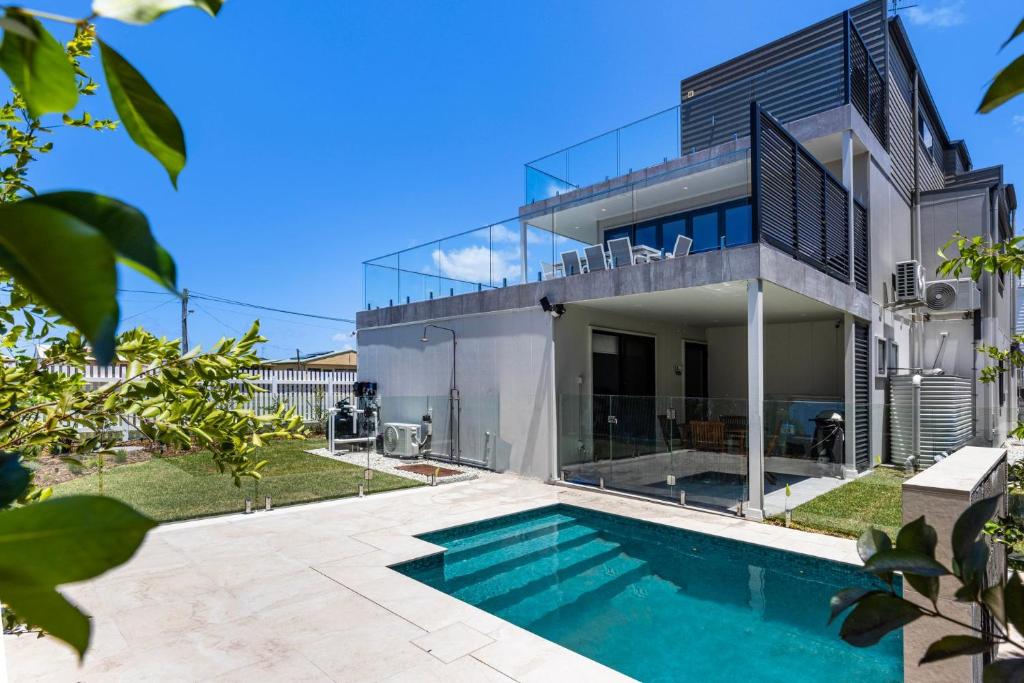 a house with a swimming pool in front of it at Bellagio - Swimming Pool with Ocean Views in Callala Beach
