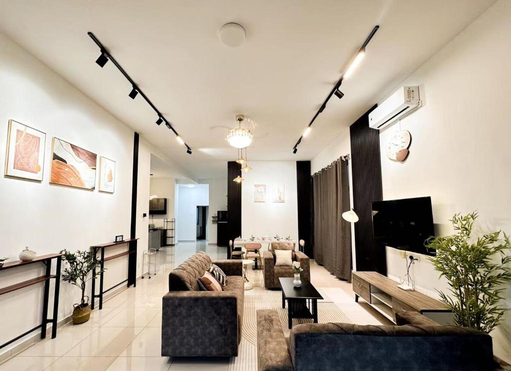 ein großes Wohnzimmer mit Sofas und Fernseher in der Unterkunft Kulim Modern Bungalow in Kulim
