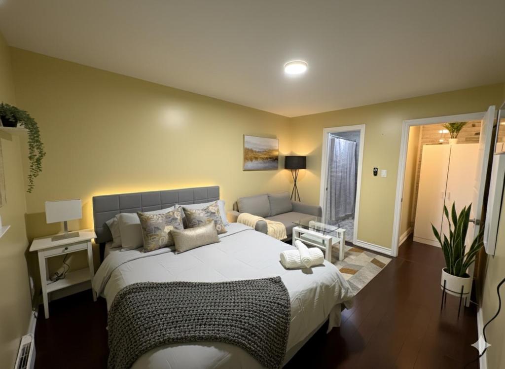 een slaapkamer met een groot bed en een bank bij Chapman H in Toronto