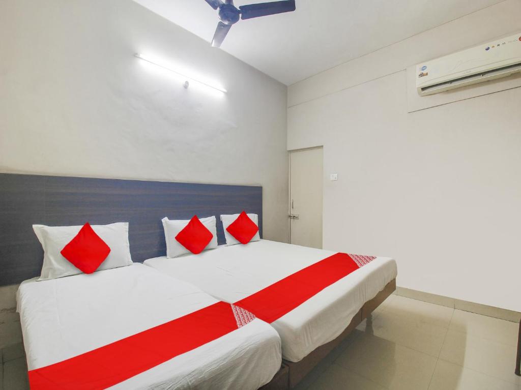 een slaapkamer met een groot bed met rode en witte kussens bij Hotel O Bharat Lodge in Ameerpet