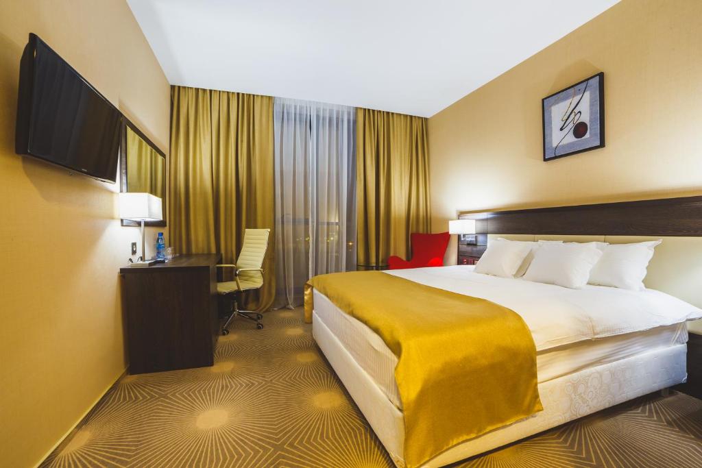 クルスクにあるAquamarine hotel&spaの大きなベッドとデスクが備わるホテルルームです。
