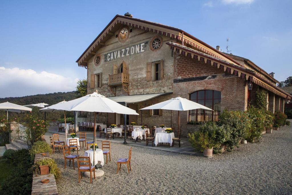 un restaurant avec des tables et des parasols en face d'un bâtiment dans l'établissement Agriturismo Cavazzone, à Regnano