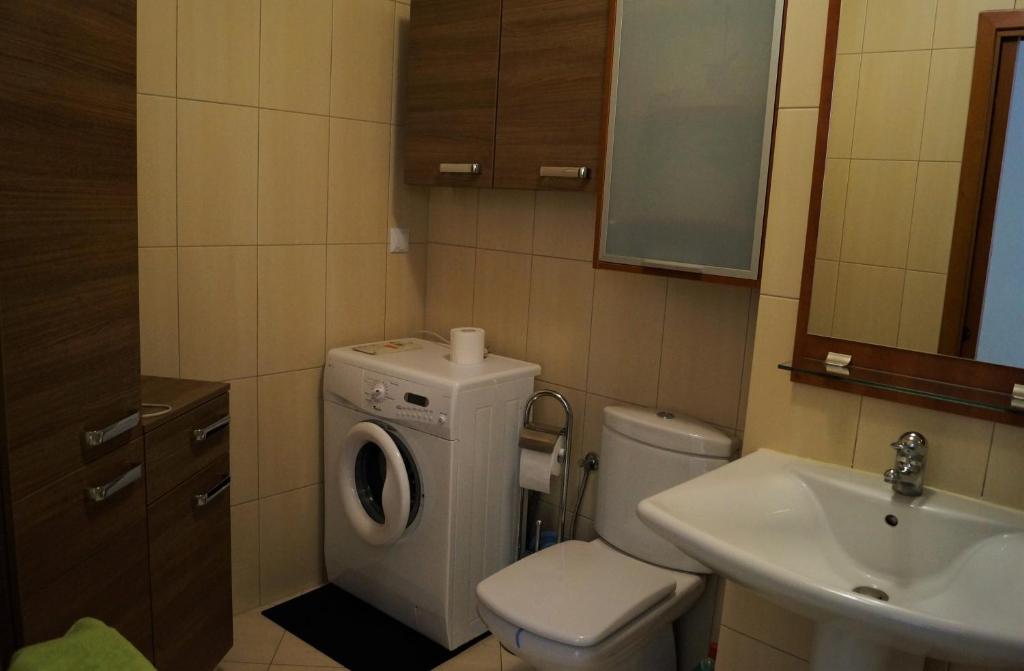 łazienka z toaletą, umywalką i pralką w obiekcie Apartament Maria w mieście Międzyzdroje