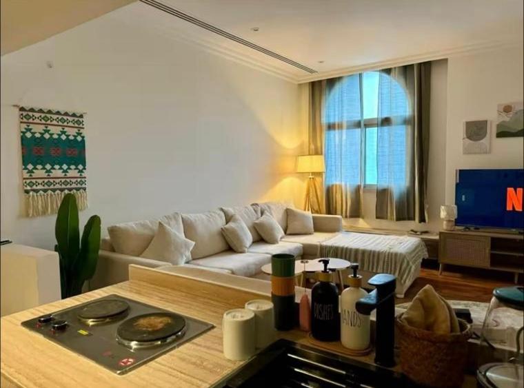 een woonkamer met een witte bank en een tafel bij #أستديو إطلالة الرياض in Riyad