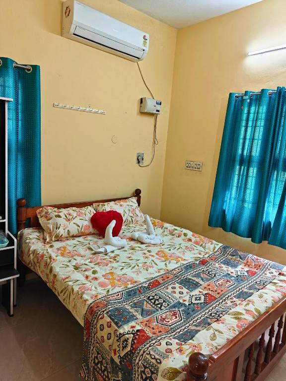 a bedroom with a bed with a stuffed animal on it at Nilan Aarudhra Homestay in Chidambaram