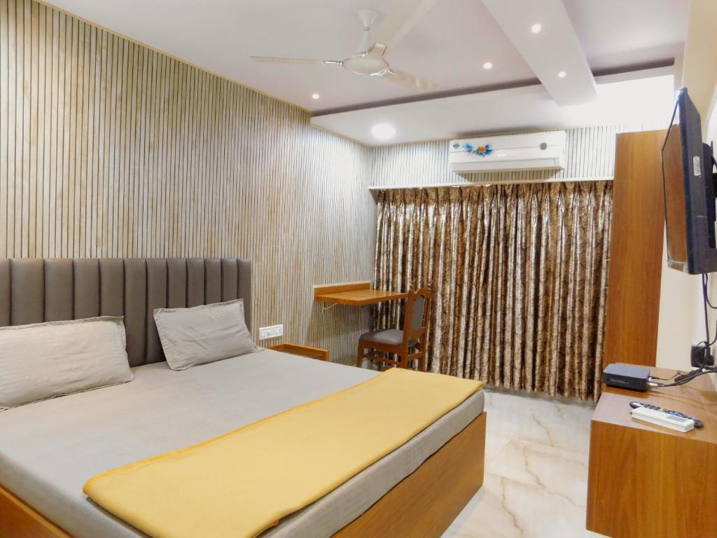 a bedroom with a bed and a television in it at Hotel Nest In in Mumbai