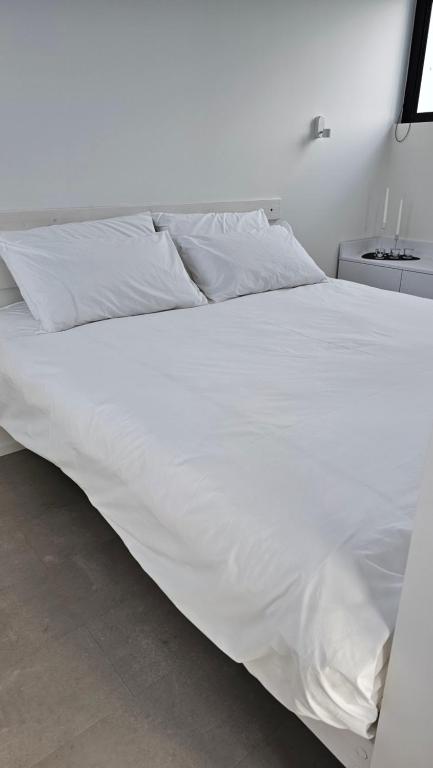 a white bed with white sheets and pillows at Interno 8 in Padova