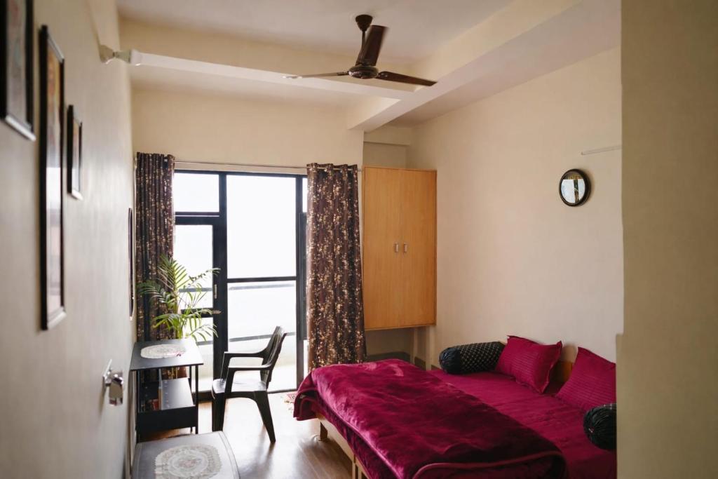 une chambre avec un lit rouge et une fenêtre dans l'établissement LVMR MIDTOWN STUDIO APARTMENT Shamshi, à Kulu