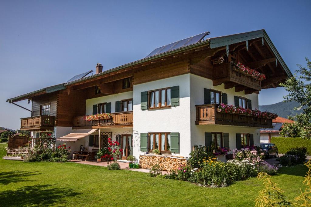 een groot huis met balkons op een groen gazon bij Ferienwohnungen Haus Martin in Inzell