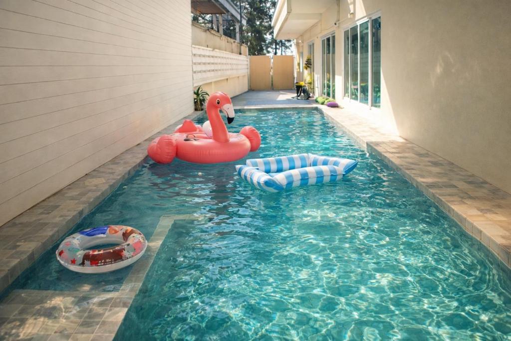 een zwembad met twee opblaasbaar speelgoed erin bij Areava Pool Villa Cha-am บ้านพักชะอำ พูลวิลล่า ติดชายหาดชะอำ in Cha Am