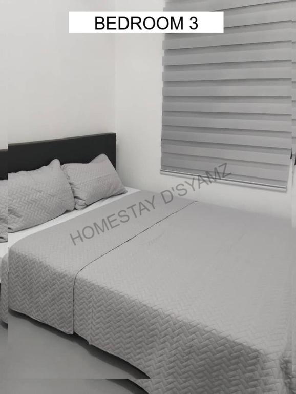 a white bedroom with a bed with a window at D'Syamz Homestay in Malacca