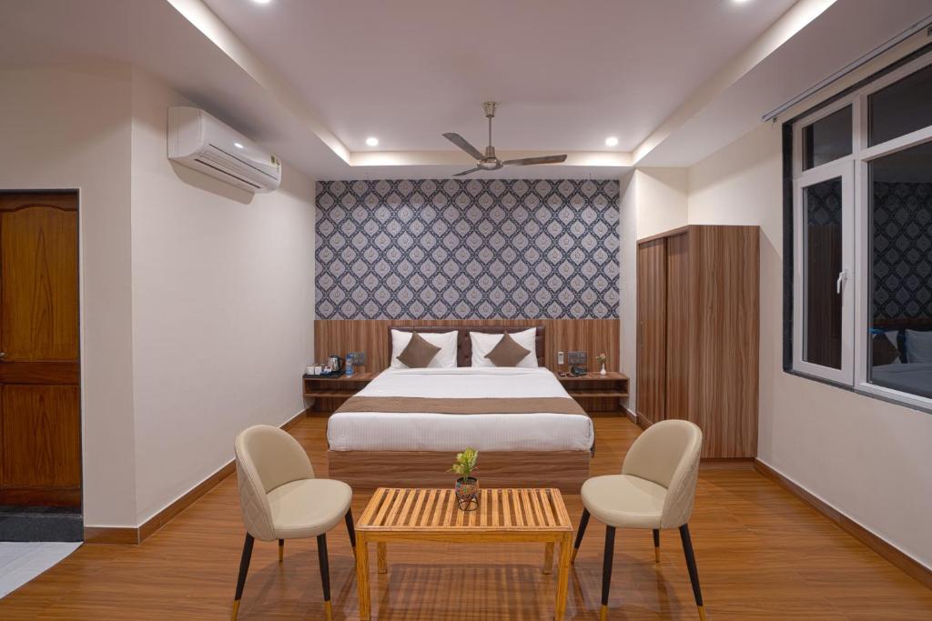 a bedroom with a bed and two chairs and a table at The Parmatma Hotel in Udaipur
