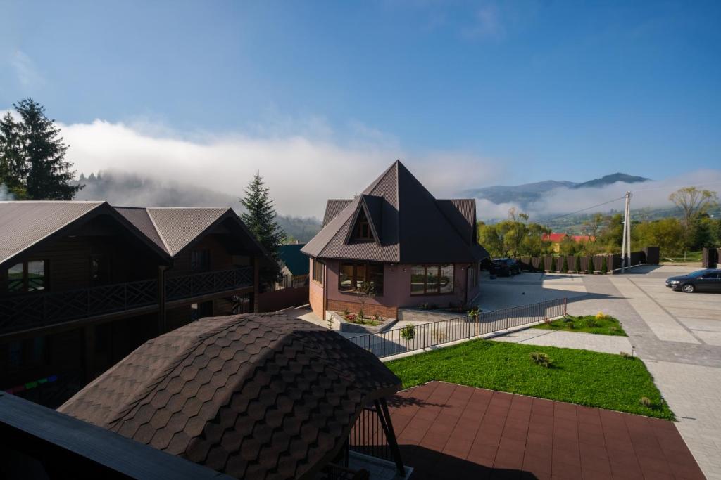 a house with a black roof on a balcony at Шепіт Карпат in Yasinya
