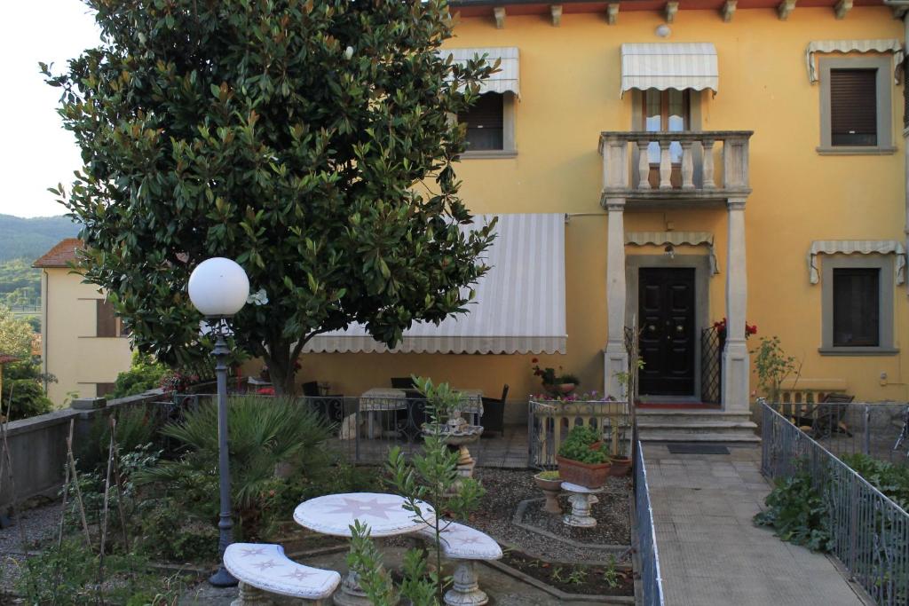 a yellow house with a tree in front of it at B&B Il Castello in Castiglion Fibocchi
