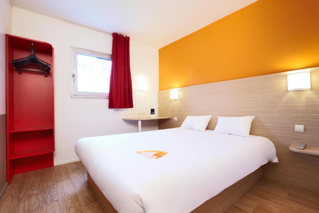 a bedroom with a large white bed and a red door at Premiere Classe Le Havre Centre-LES DOCKS in Le Havre