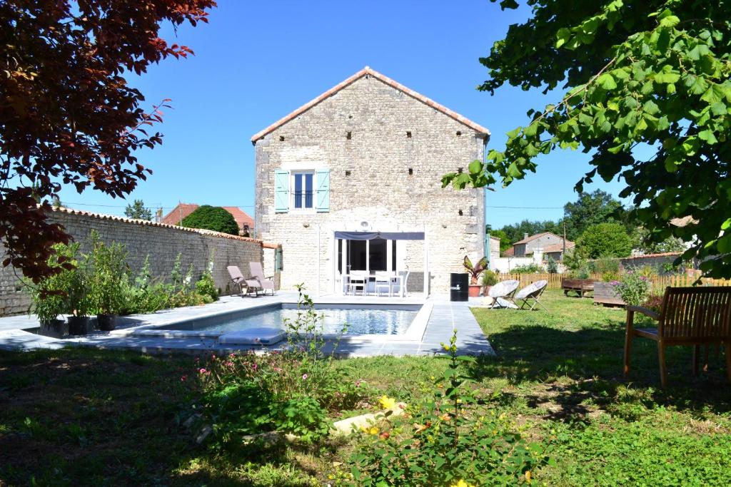 an external view of a stone house with a swimming pool at La Grange aux Dames in Genac