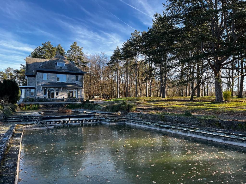 a large house with a pond in front of it at Aux étangs fleuris in Rochefort