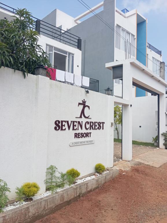een witte muur met een bord voor een resort met zeven gasten bij Seven Crest Hotel Anuradhapura in Anuradhapura