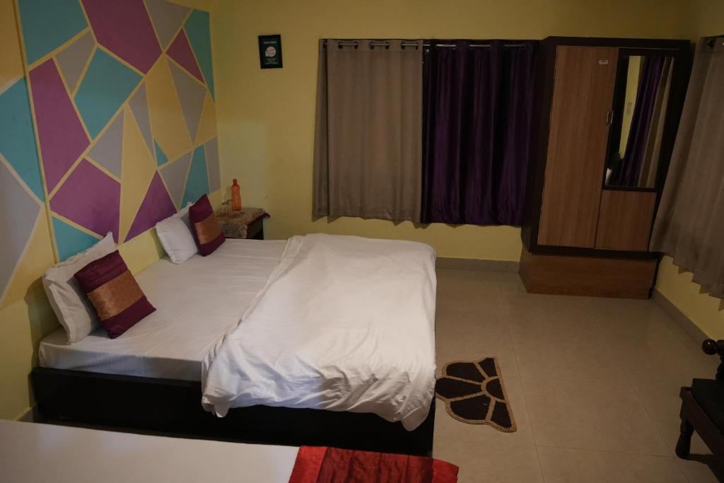 ein Schlafzimmer mit einem Bett mit einer farbenfrohen Wand in der Unterkunft Himalaya View Resort in Mukteswar