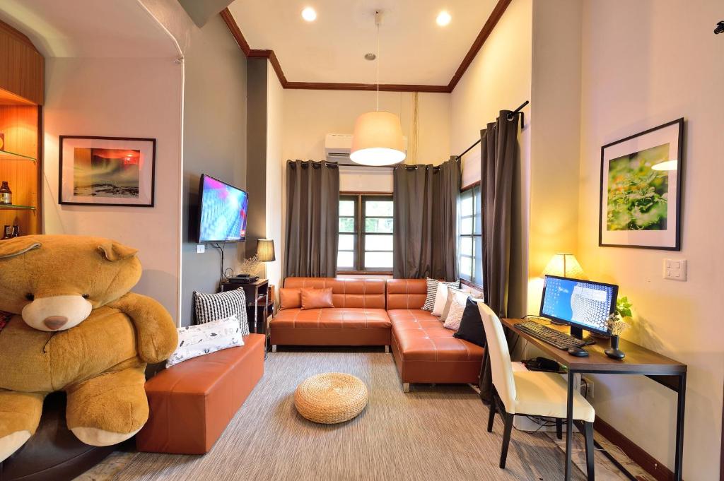 una sala de estar con un osito de peluche grande sentado en un sofá en Lost and Found Bed and Breakfast, en Bangkok