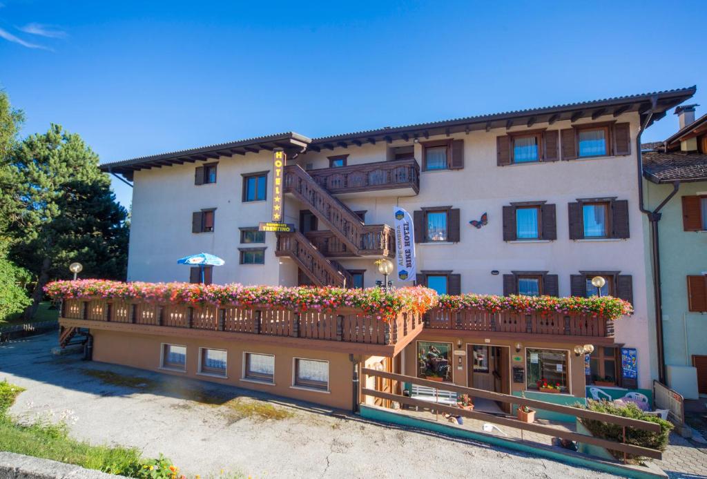 a large building with flowers on a balcony at Hotel Trentino in Folgaria