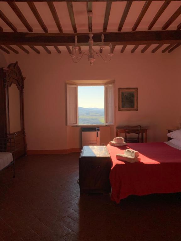 una camera da letto con due letti e una grande finestra di Casa Cerboneschi a Casale Marittimo