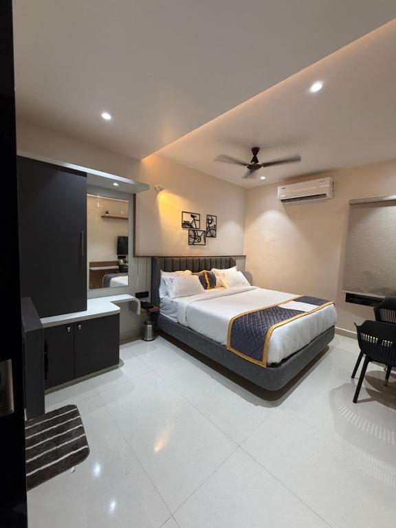 a bedroom with a large bed and a television at Palukuri's Grand in Vizianagram City