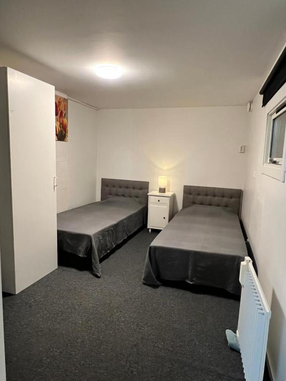 a bedroom with two beds and a door to a room at Mini Hus in Märsta