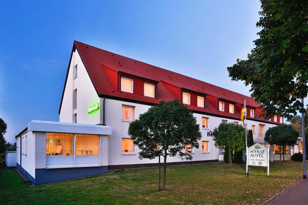 un grand bâtiment blanc avec un toit rouge dans l'établissement Hanse Hotel, à Soest