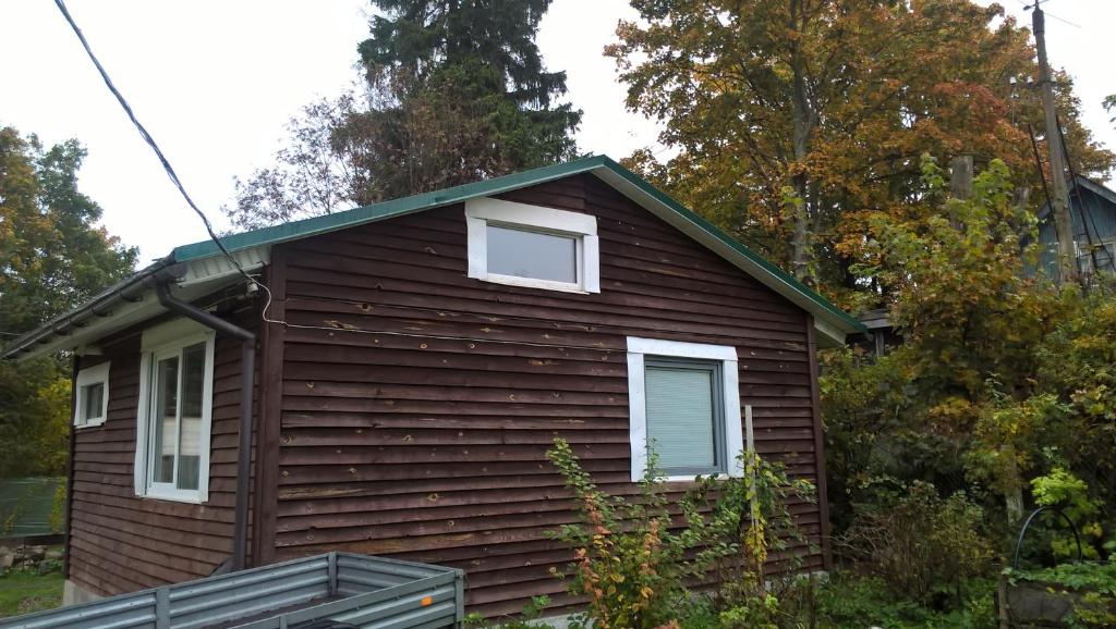 トクソヴォにあるGuest House Uyutの緑の屋根の小さな茶色の家