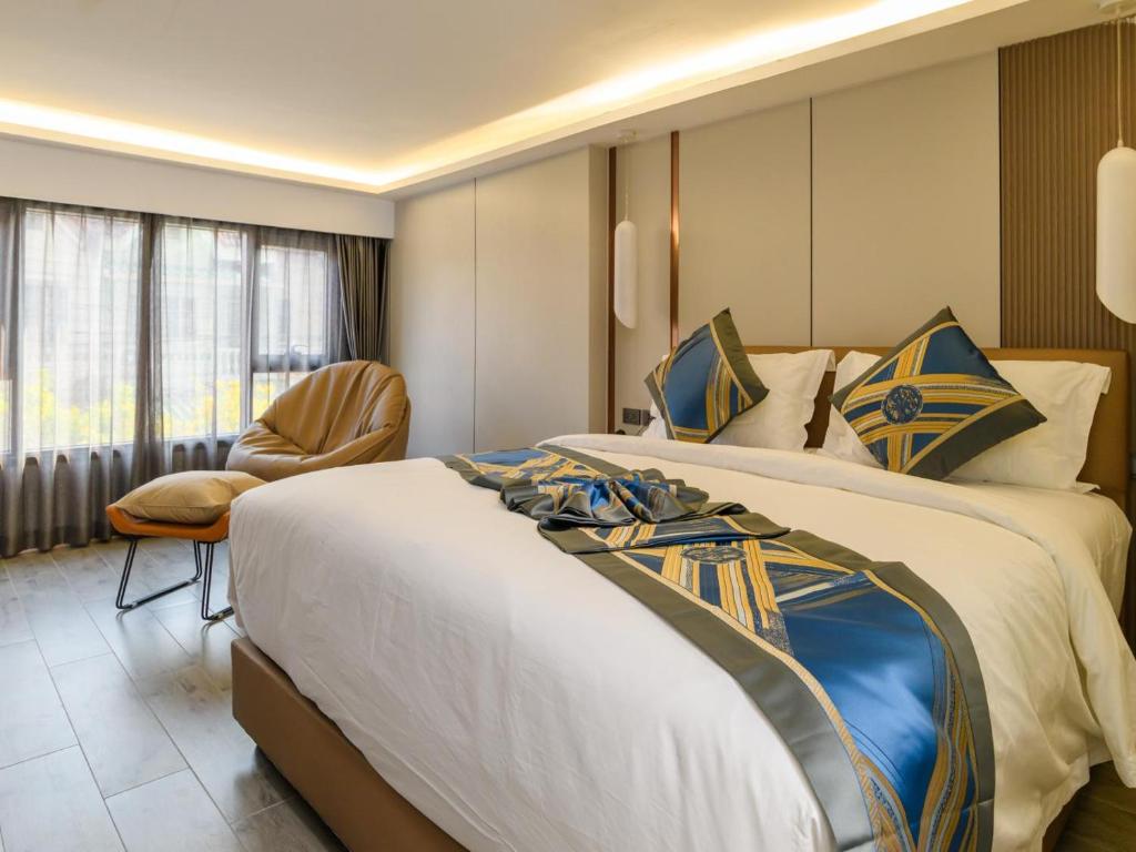 une chambre d'hôtel avec deux lits et une chaise dans l'établissement 酒店MARQUIS HOTEl, à Ban Bang Toei (1)