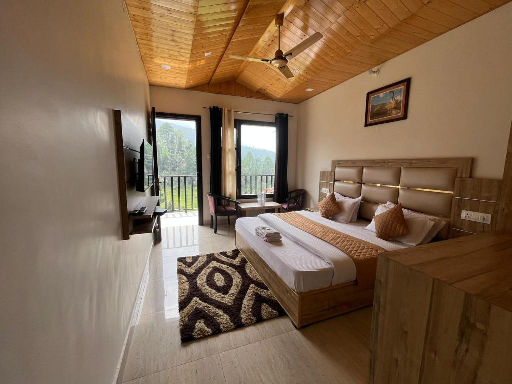 ein Schlafzimmer mit einem Bett und einem Fernseher darin in der Unterkunft Hotel Forest View Dalhousie, Banikhet in Dalhousie