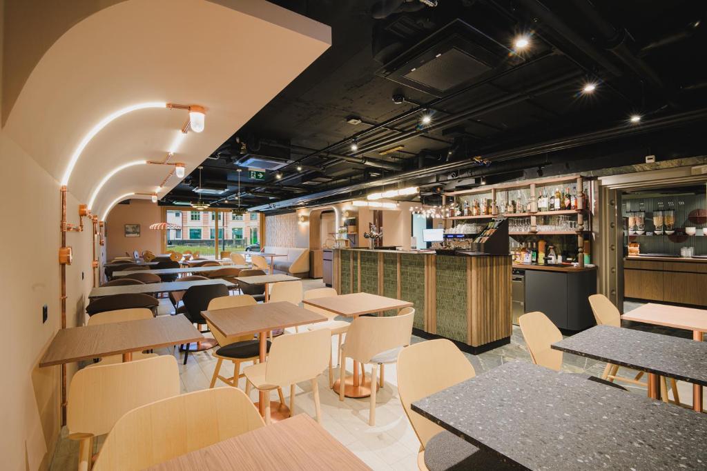 a restaurant with tables and chairs and a bar at Hota Hotel Porrentruy in Porrentruy