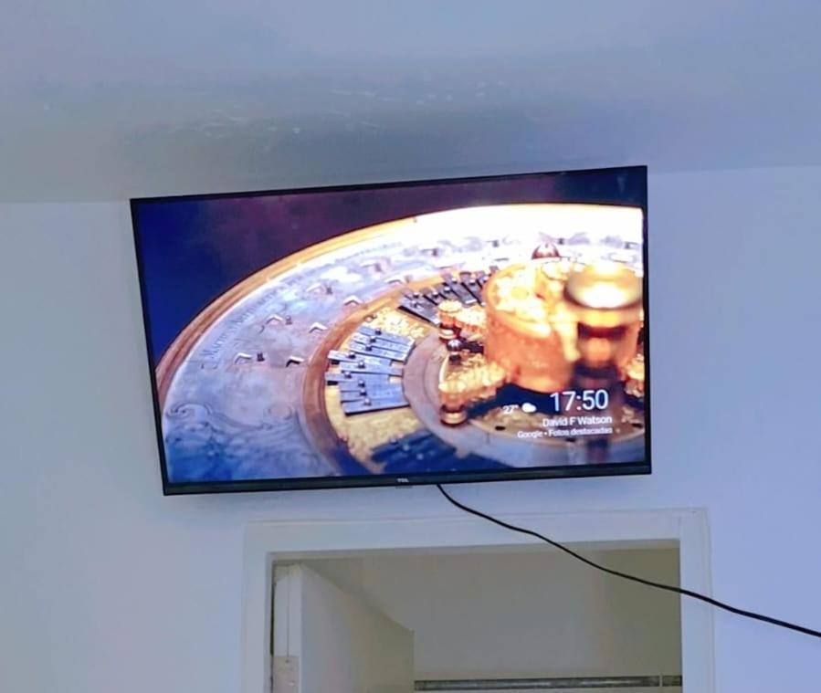 een flatscreen-tv op een muur bij 4 vecinos in Santiago de los Caballeros
