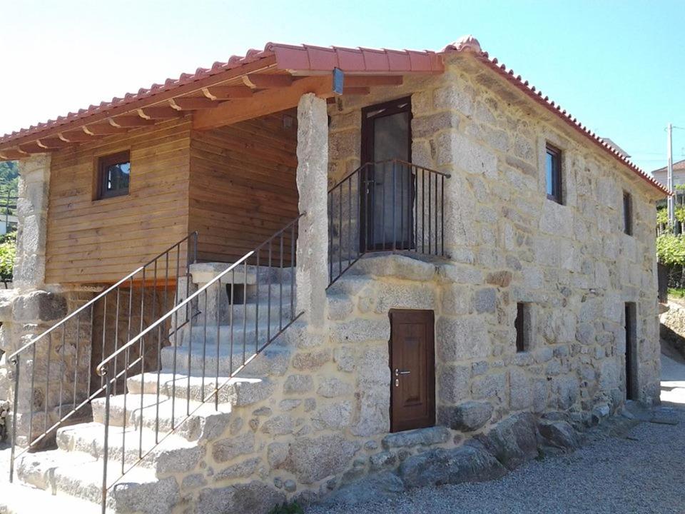 una casa de piedra con una escalera que conduce a una puerta en Casa da Corga, en Portela