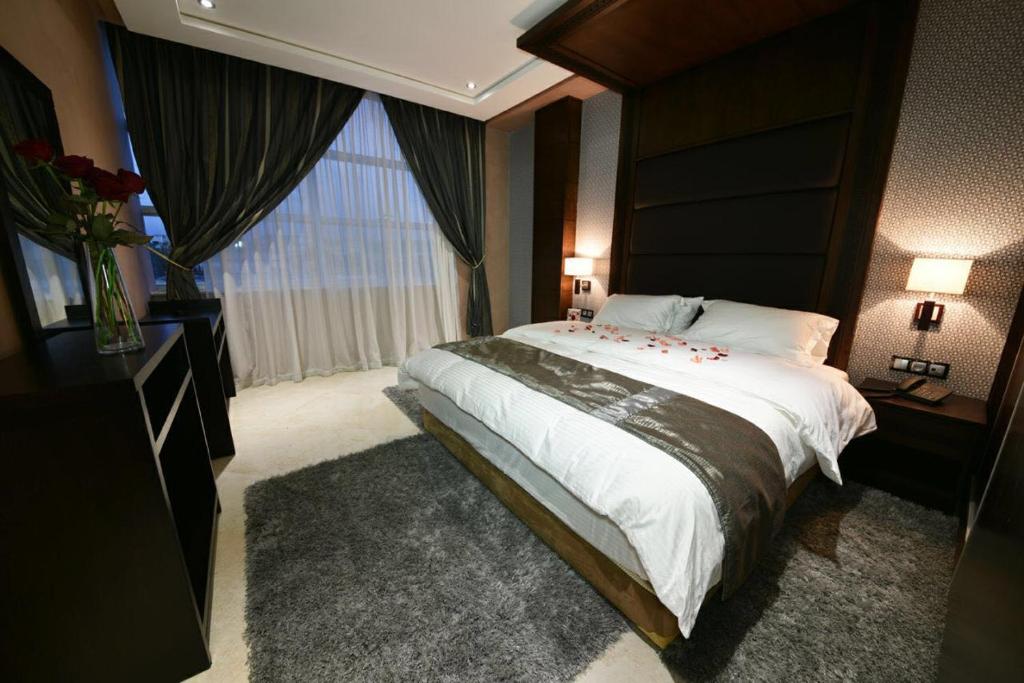 sypialnia z dużym łóżkiem i dużym oknem w obiekcie Bellington Appart Hôtel w mieście Saïdia