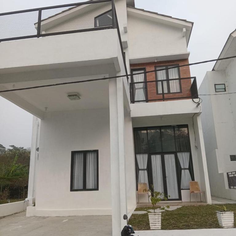 a house with white walls and windows at Tropical garden regency N2 in Sibolangit
