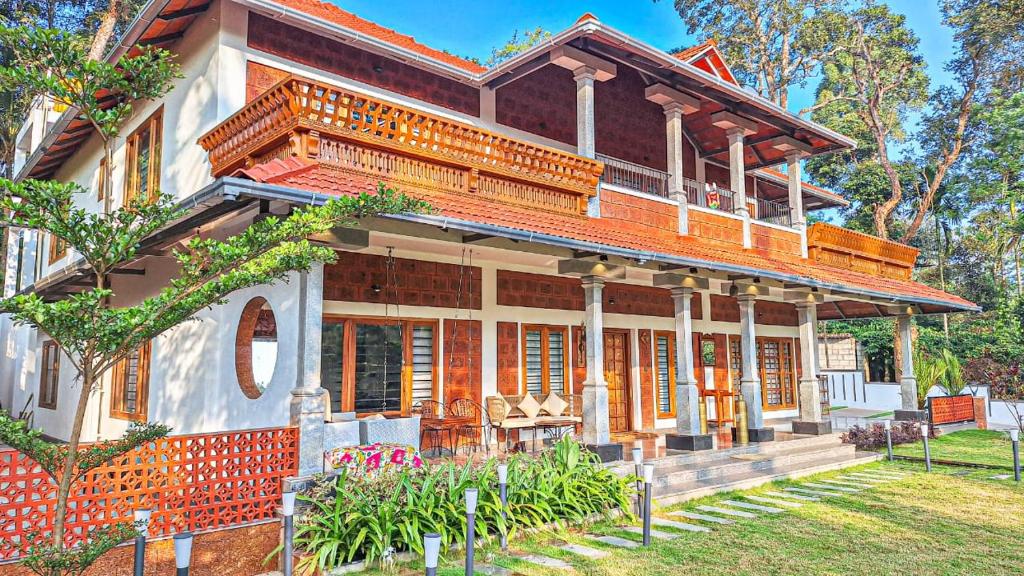 a large house with a porch and a garden at 1st Miracle By Mirth, Mythadi , Coorg in Ammatti