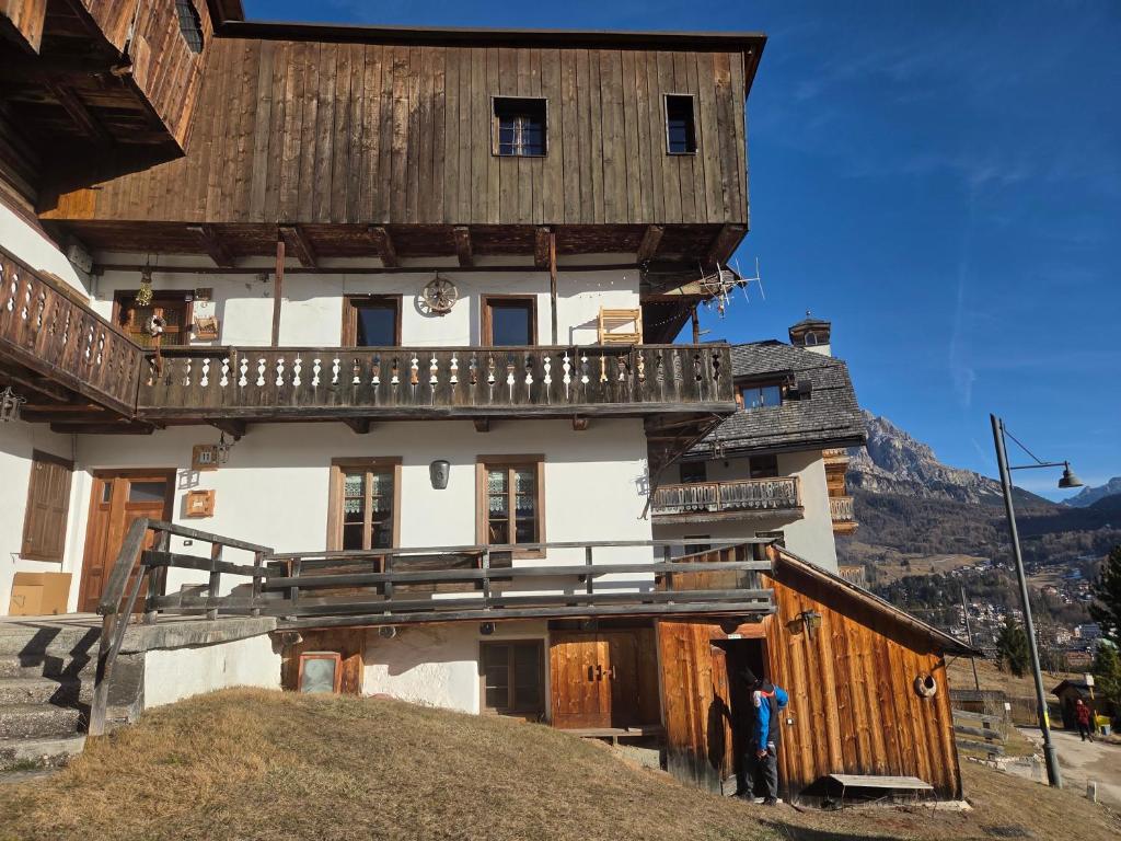 een groot huis met een houten dak op een heuvel bij Meleres 11 in Cortina dʼAmpezzo