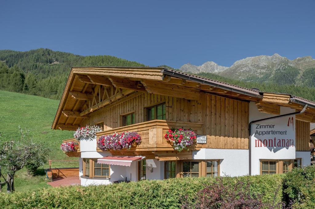 ein Gebäude mit Blumenkästen an der Seite in der Unterkunft Montanara in Sölden