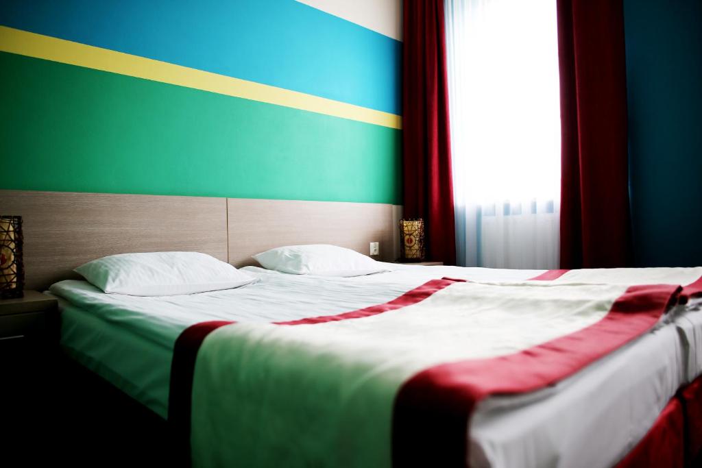 a bedroom with a large bed with a colorful wall at Hotel Folklor in Międzyrzec Podlaski