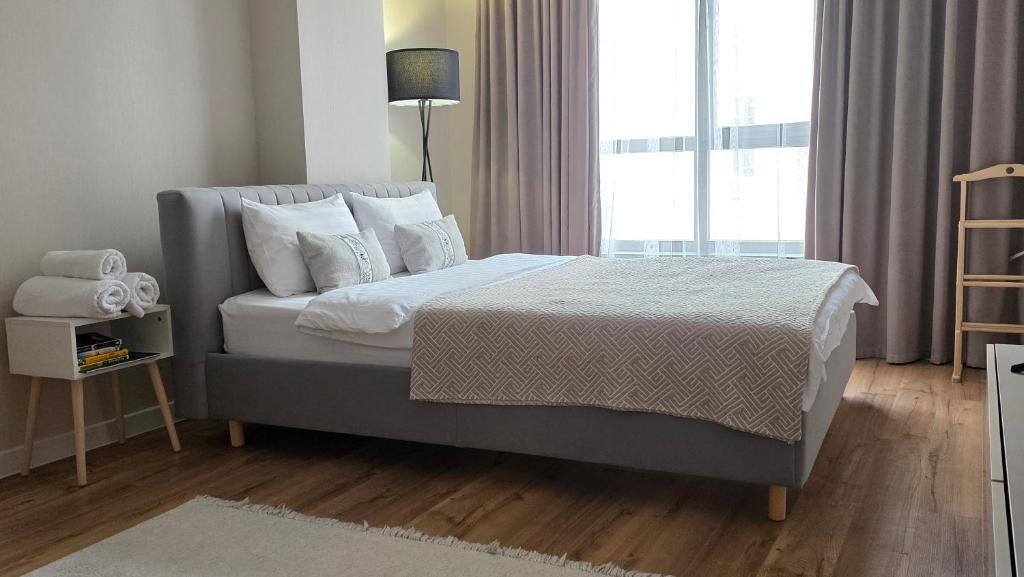 een slaapkamer met een bed en een groot raam bij Residence Apartment Osh Шикарные апартаменты в самом Элитном районе города Ош in Osh