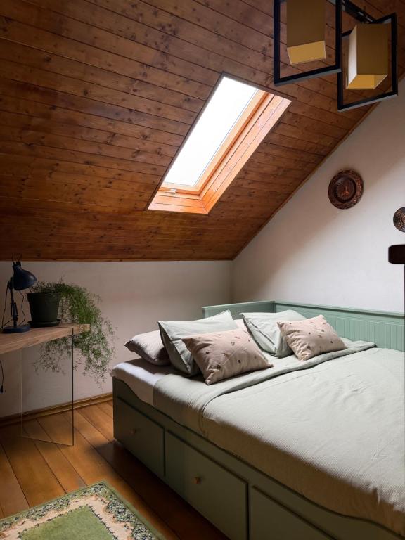 une chambre avec un grand lit avec une lucarne dans l'établissement Grandma’s Cottage, à Săcele