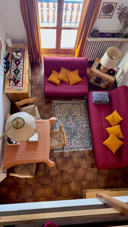 a living room with a purple couch and yellow pillows at Facing the Sestriere Ski Slopes in Borgata Sestriere