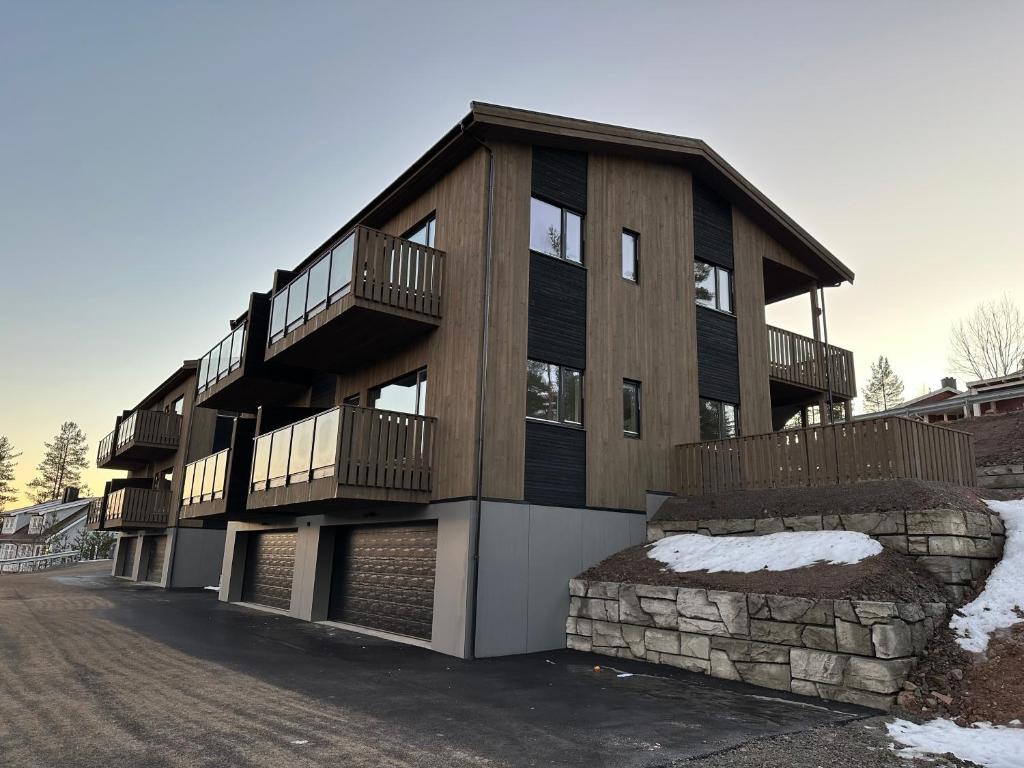ein großes Holzgebäude mit Balkonen an einer Straße in der Unterkunft Motoppen Trysil Aparments in Trysil