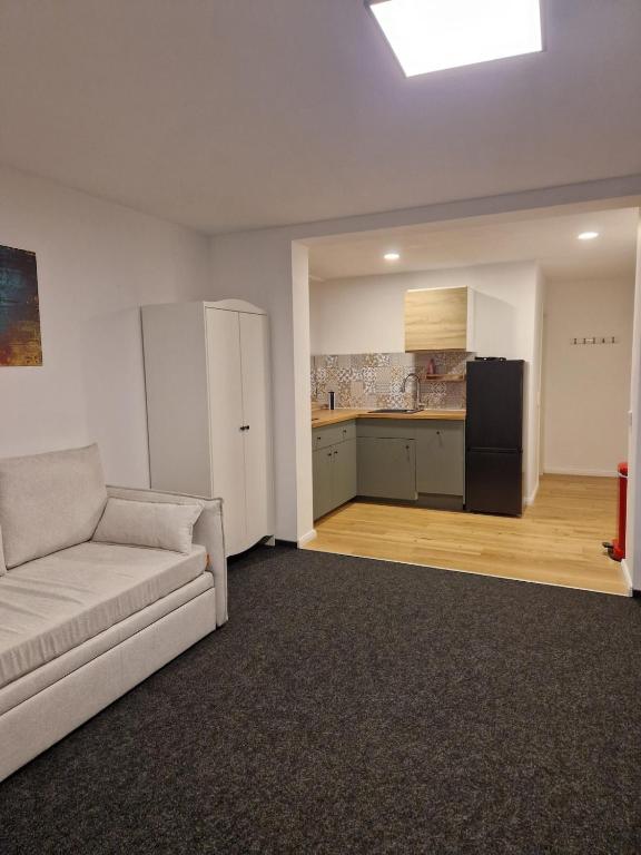 a living room with a couch and a kitchen at Modernes Apartment in Huttenberg